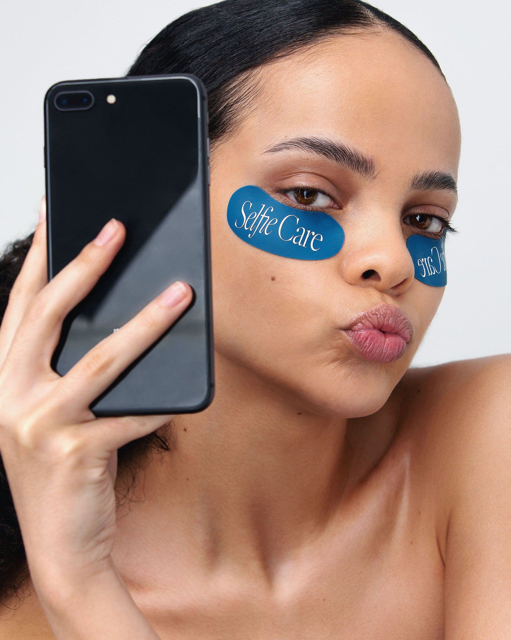 Close-up of model using eco-friendly reusable eye masks for refreshed, glowing skin