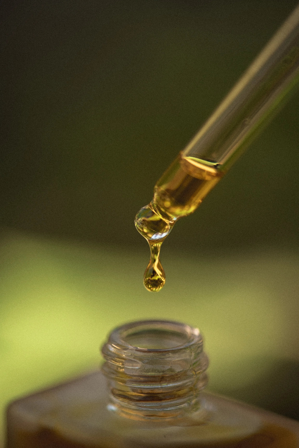 Close-up of Frequencia Ritual Serum dropper showcasing rich botanical facial oil