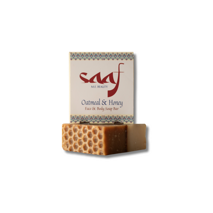 A bar of oatmeal and honey soap with a honeycomb pattern on the top, packaged in a card with the brand 'Saaf' and product name 'Oatmeal & Honey'.