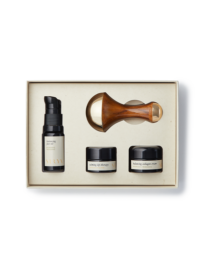 Skincare product set with bottles and a roller in a box on a white background