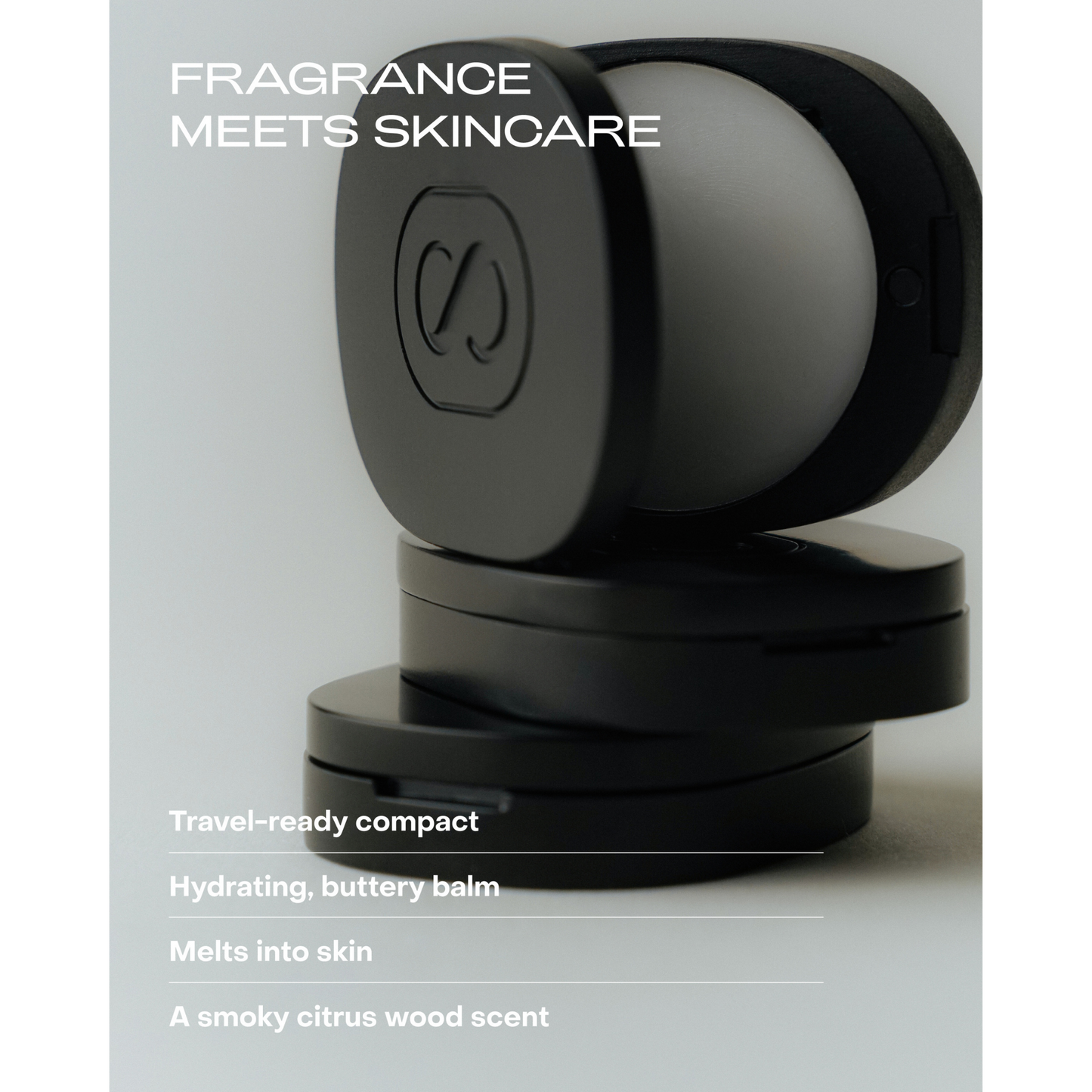 Black and gray cosmetic compact with branding on a light gray background