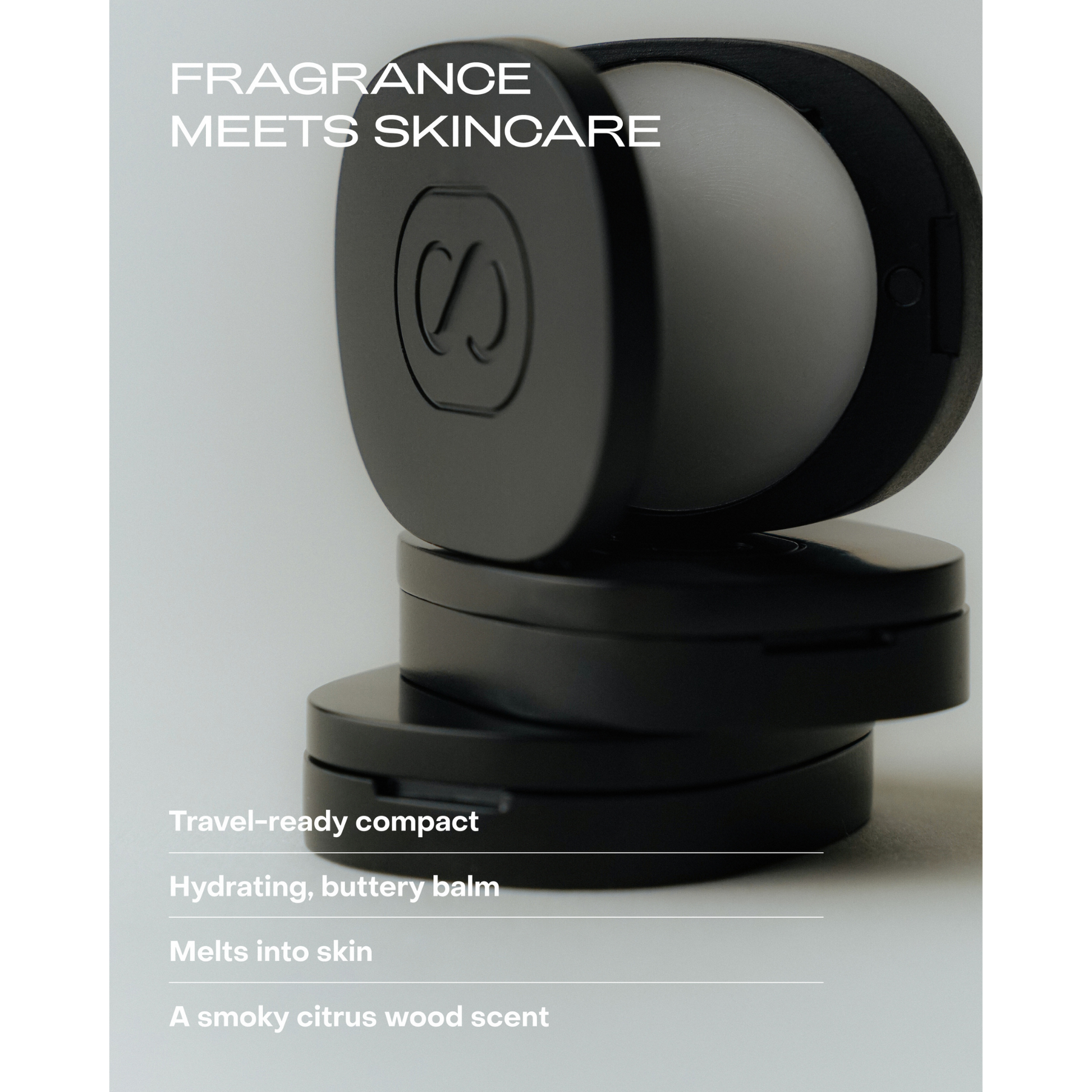 Black and gray cosmetic compact with branding on a light gray background