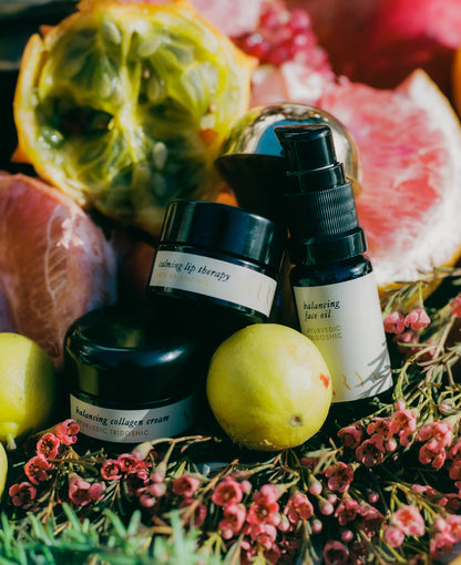 Skincare products with fruits and flowers on a colorful background